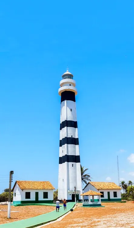 Farol listrado de preto e branco sob céu azul