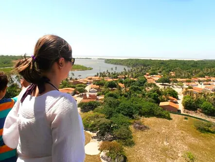 Turista observando do alto o povoado e o rio
