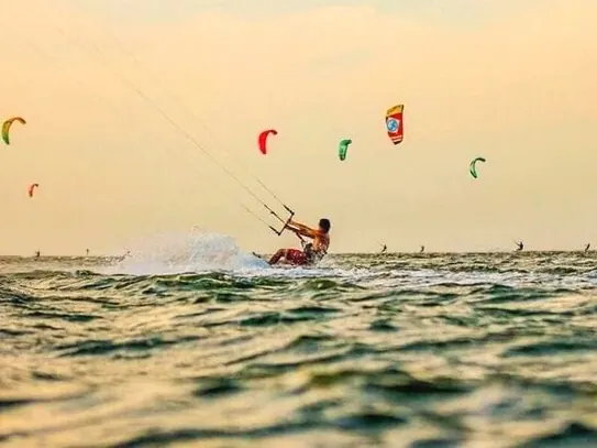 Praticantes de kitesurf no mar ao entardecer, em Atins